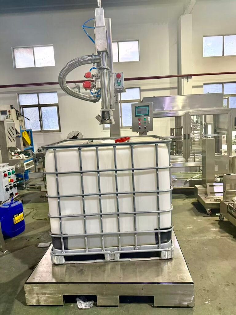 IBC filling machine with 1000 L tote positioned beneath a filling nozzle in workshop